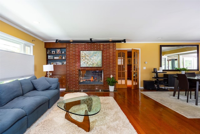 living room with ornamental molding, wood finished floors, recessed lighting, and a brick fireplace