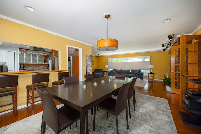 dining room with crown molding, wood finished floors, and recessed lighting