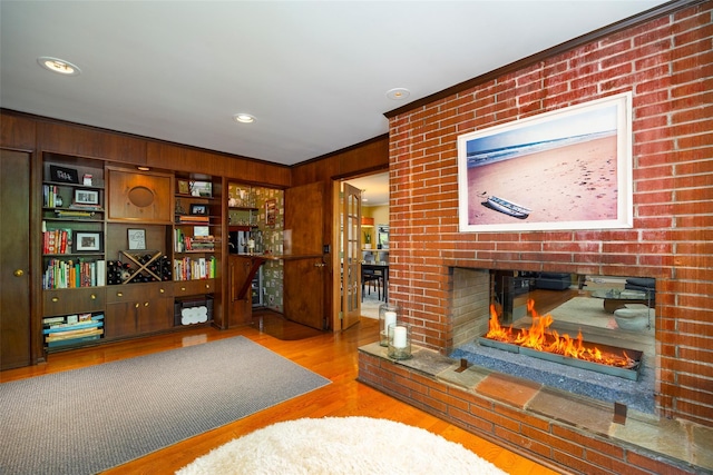 living room with a fireplace, wood finished floors, wooden walls, and recessed lighting