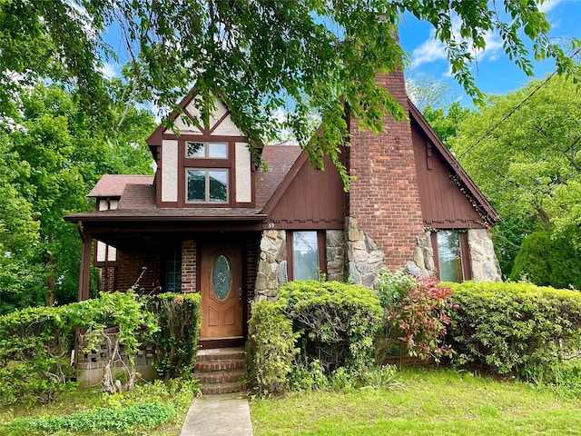 59 Sunset Rd, Bay Shore, NY 11706 - tudor house with a chimney, stone siding, and roof with shingles