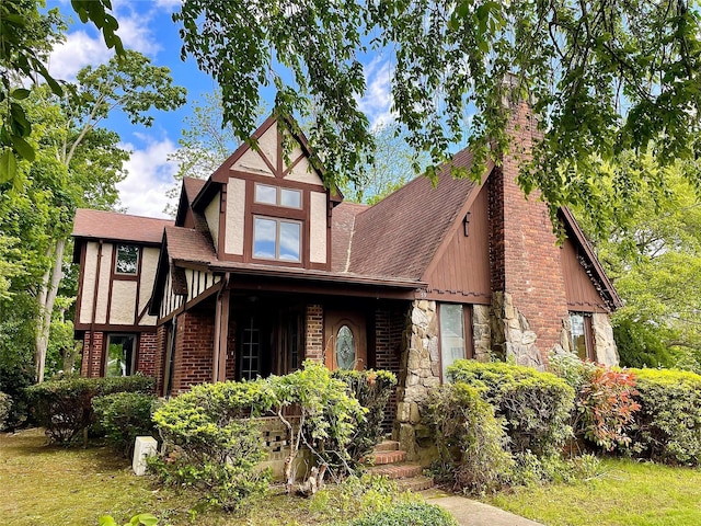 59 Sunset Rd, Bay Shore, NY 11706 - tudor home featuring stone siding, a chimney, and a shingled roof
