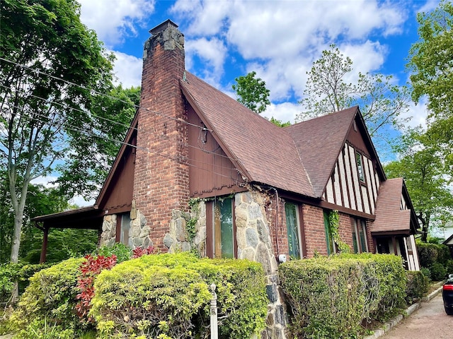 59 Sunset Rd, Bay Shore, NY 11706 - view of side of property with a chimney, stone siding, and a shingled roof