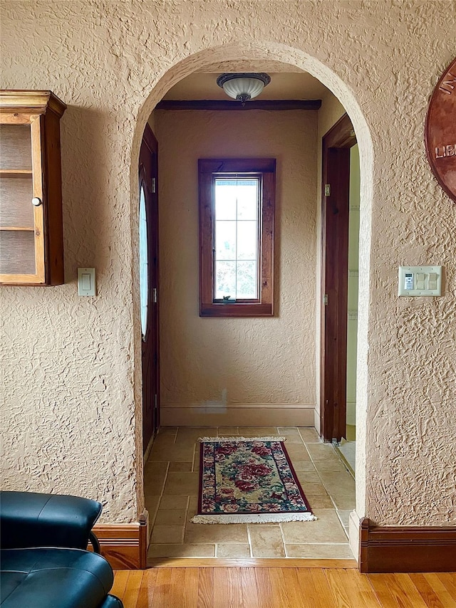 59 Sunset Rd, Bay Shore, NY 11706 - corridor featuring arched walkways, baseboards, wood finished floors, and a textured wall