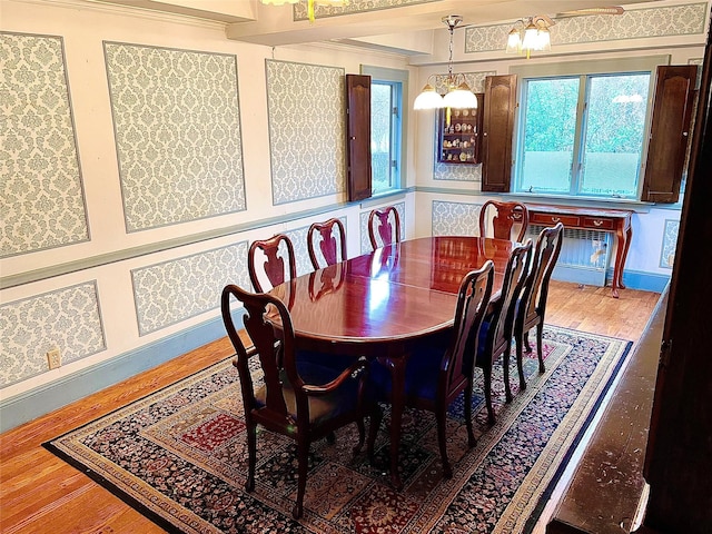 59 Sunset Rd, Bay Shore, NY 11706 - dining room featuring wood finished floors, a chandelier, and crown molding