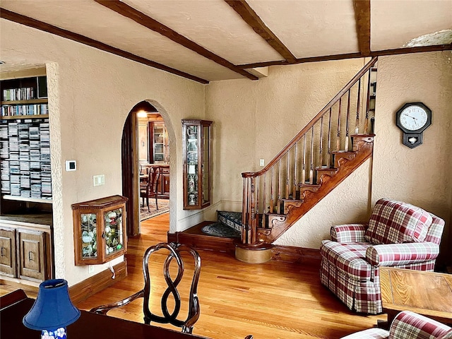 59 Sunset Rd, Bay Shore, NY 11706 - entrance foyer featuring a textured wall, arched walkways, wood finished floors, beamed ceiling, and stairway
