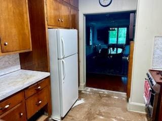 59 Sunset Rd, Bay Shore, NY 11706 - kitchen with freestanding refrigerator, gas range, brown cabinetry, and light countertops