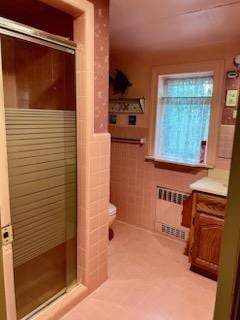 59 Sunset Rd, Bay Shore, NY 11706 - full bath featuring radiator, a stall shower, wainscoting, vanity, and tile walls