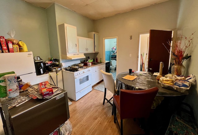 60-85 55th St, Maspeth, NY 11378 - kitchen with white appliances, white cabinets, light wood-type flooring, and under cabinet range hood