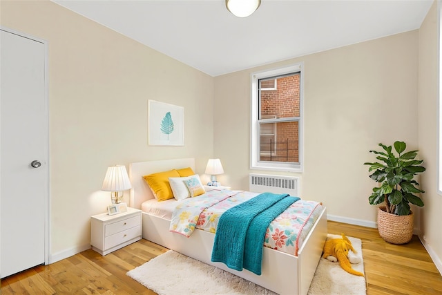 67-30 Clyde St Unit 6W, Forest Hills, NY 11375 - bedroom with radiator, wood finished floors, and baseboards