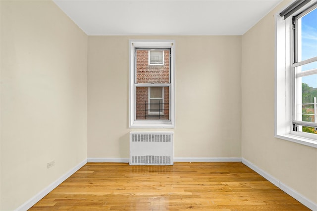 67-30 Clyde St Unit 6W, Forest Hills, NY 11375 - spare room featuring radiator heating unit, baseboards, and light wood-style flooring