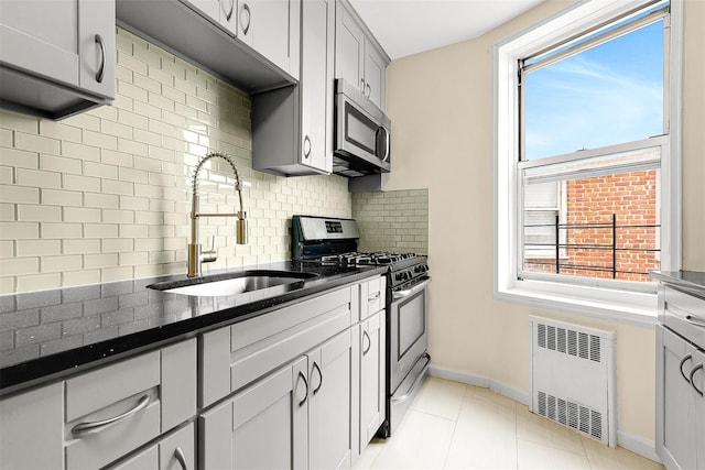67-30 Clyde St Unit 6W, Forest Hills, NY 11375 - kitchen featuring appliances with stainless steel finishes, radiator, a sink, backsplash, and healthy amount of natural light