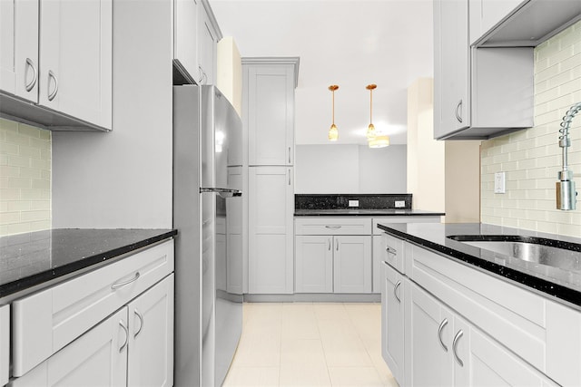 67-30 Clyde St Unit 6W, Forest Hills, NY 11375 - kitchen with freestanding refrigerator, a sink, backsplash, and dark stone counters
