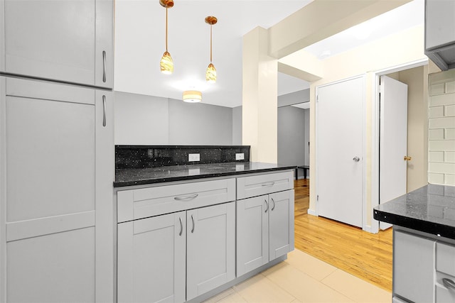67-30 Clyde St Unit 6W, Forest Hills, NY 11375 - kitchen with dark stone counters, hanging light fixtures, and light wood-style floors