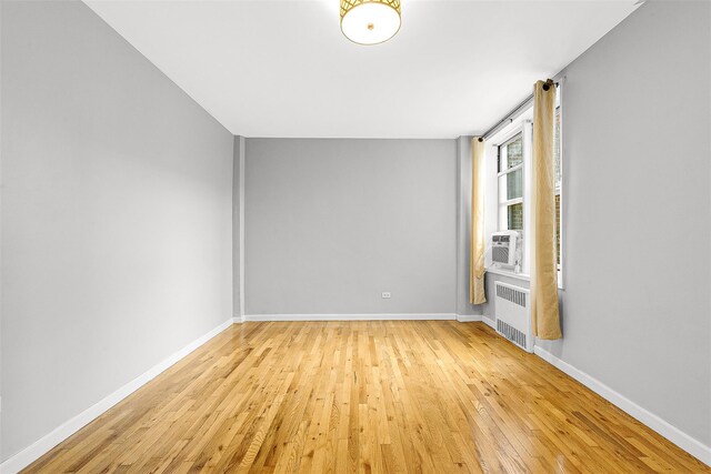 67-30 Clyde St Unit 6W, Forest Hills, NY 11375 - empty room featuring radiator heating unit, light wood-type flooring, and baseboards