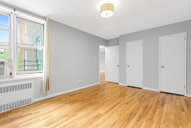 67-30 Clyde St Unit 6W, Forest Hills, NY 11375 - unfurnished bedroom with radiator heating unit, wood finished floors, and baseboards
