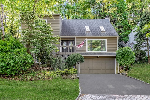 view of front of home featuring driveway, a shingled roof, a garage, and a front yard