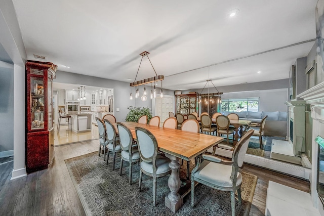dining area featuring a chandelier, light wood-type flooring, baseboards, and recessed lighting