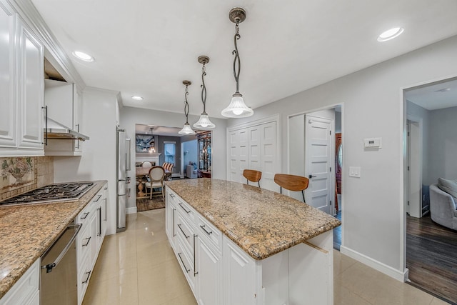 kitchen with stainless steel appliances, tasteful backsplash, white cabinets, recessed lighting, and pendant lighting