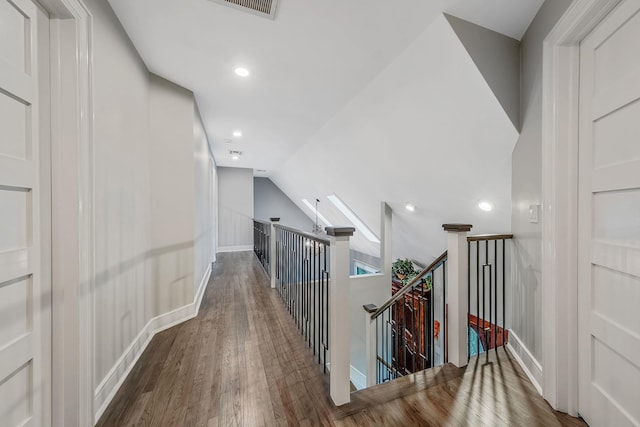 corridor featuring an upstairs landing, wood finished floors, lofted ceiling, recessed lighting, and baseboards