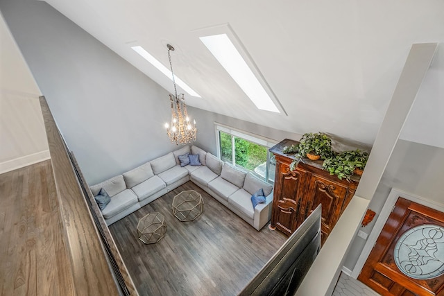 living area with a skylight, lofted ceiling, a chandelier, and wood finished floors