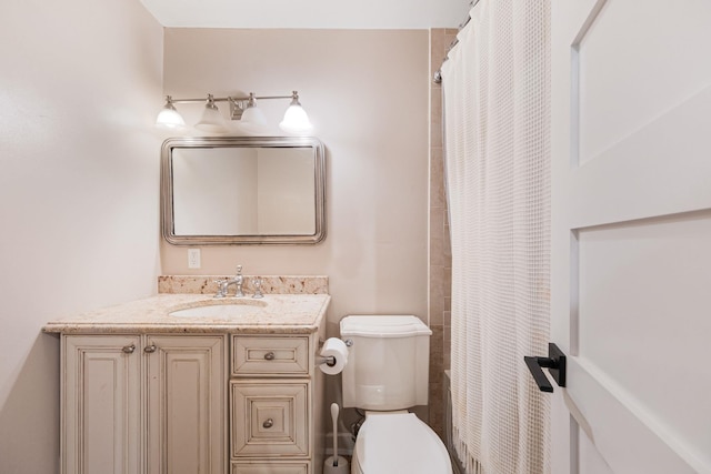 bathroom with toilet, vanity, and curtained shower