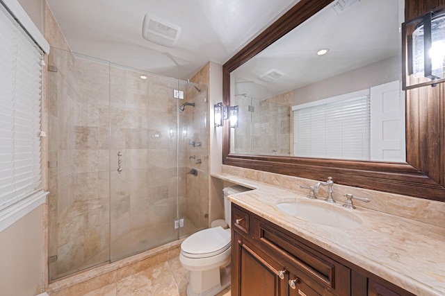 bathroom with toilet, a stall shower, and vanity
