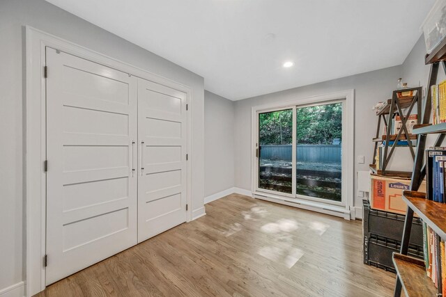 unfurnished living room featuring wood finished floors, recessed lighting, and baseboards