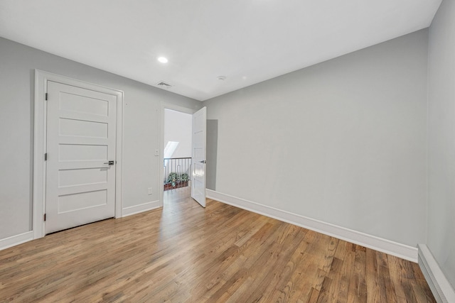 empty room featuring light wood-type flooring, baseboards, and recessed lighting