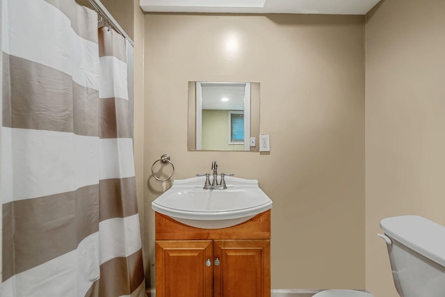 bathroom with toilet, vanity, and curtained shower