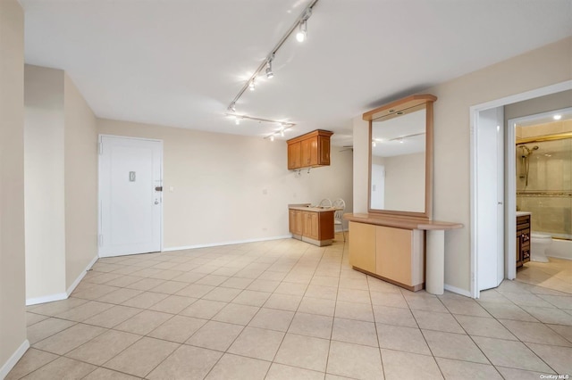 2 Bay Club Dr Unit 3Z3, Bayside, NY 11360 - kitchen with rail lighting, light tile patterned floors, baseboards, and brown cabinetry