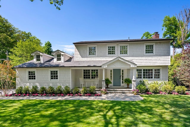 view of front of home featuring a chimney and a front yard