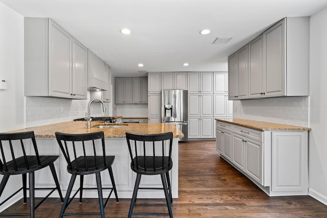 kitchen with stainless steel fridge with ice dispenser, a peninsula, gray cabinets, tasteful backsplash, and recessed lighting