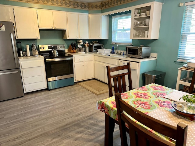 23 Hawkins Path, Coram, NY 11727 - kitchen featuring stainless steel appliances, light countertops, a sink, light wood-style floors, and white cabinetry