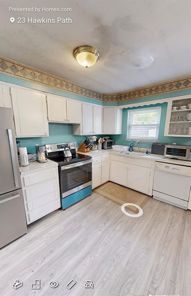 23 Hawkins Path, Coram, NY 11727 - kitchen with appliances with stainless steel finishes, a sink, light countertops, light wood finished floors, and white cabinetry