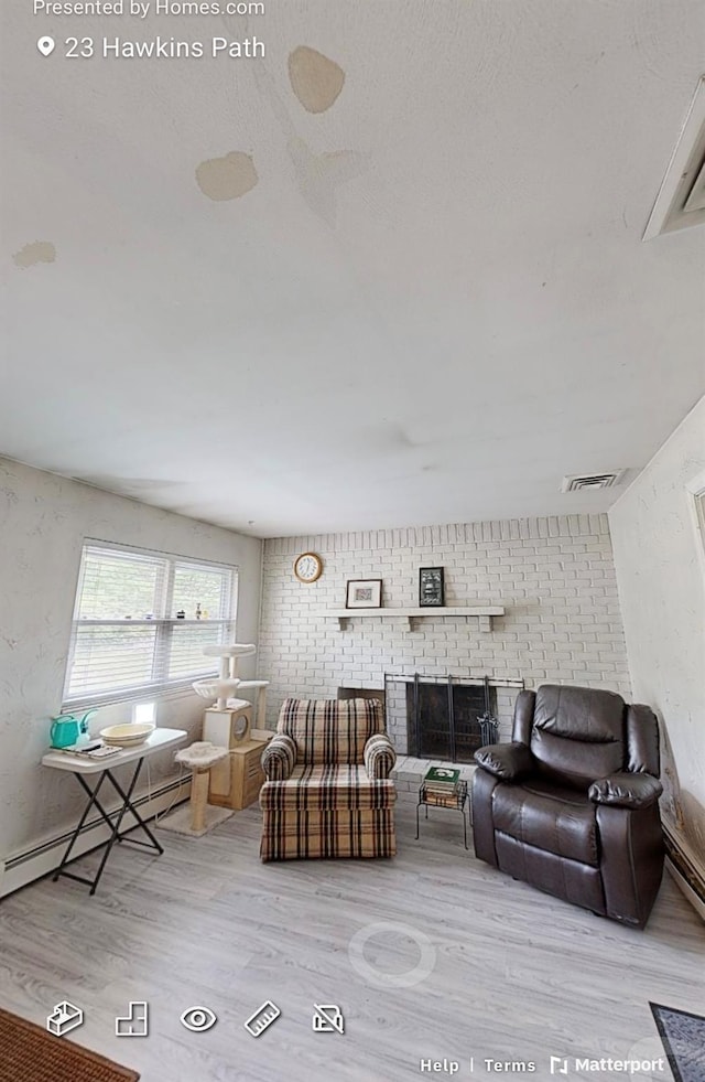 23 Hawkins Path, Coram, NY 11727 - living room with wood finished floors, baseboard heating, and a fireplace