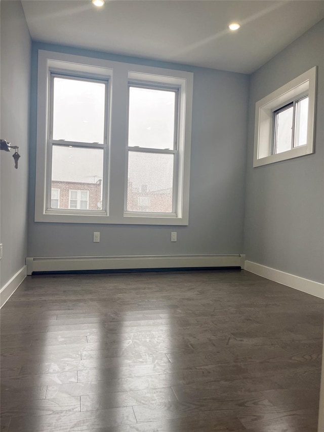 empty room with plenty of natural light, baseboards, baseboard heating, and recessed lighting