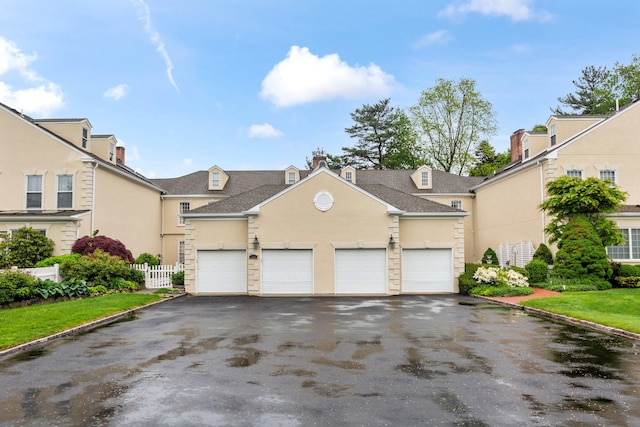 view of front of property with stucco siding, asphalt driveway, fence, a residential view, and roof with shingles