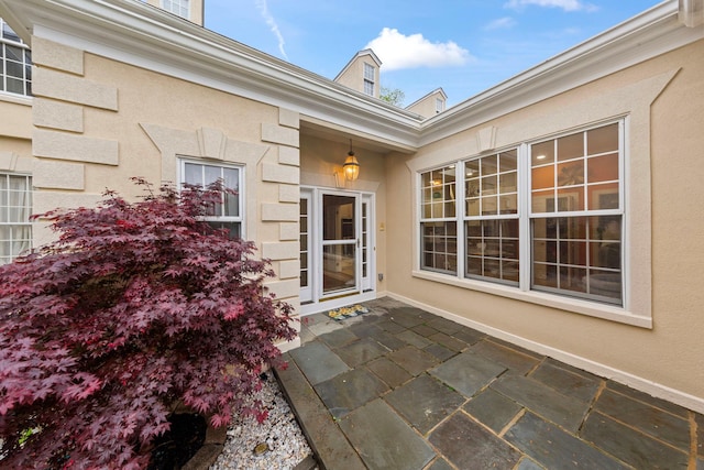 entrance to property with stucco siding and a patio