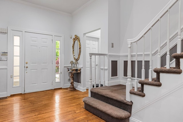 entrance foyer featuring stairs, wood finished floors, and crown molding
