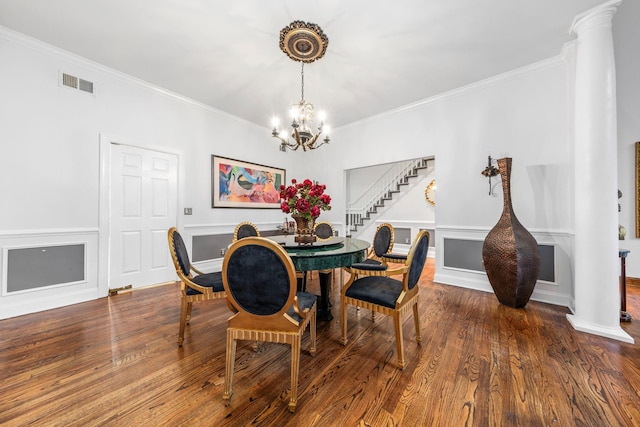 dining room featuring stairway, decorative columns, ornamental molding, a chandelier, and wood finished floors