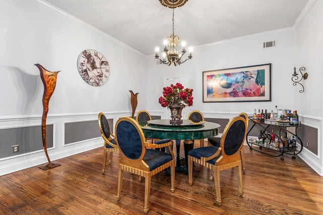 dining space with a chandelier, wood finished floors, and crown molding