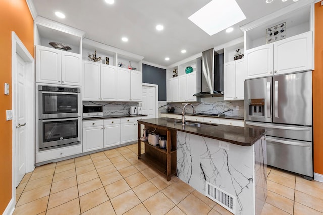 kitchen with stainless steel appliances, wall chimney exhaust hood, a sink, open shelves, and a skylight