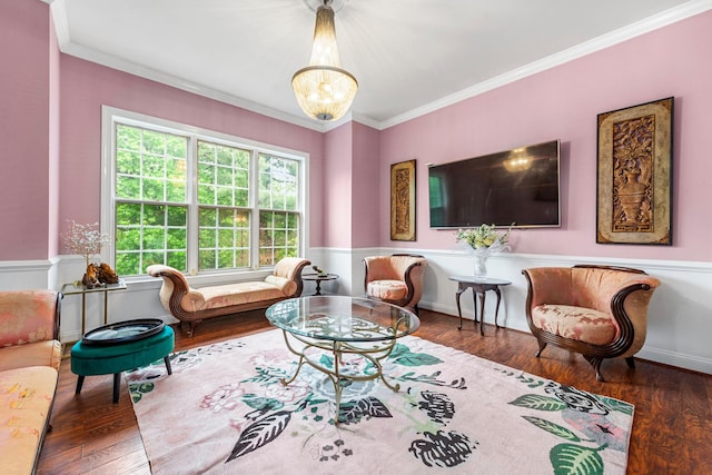 living area featuring wood finished floors, ornamental molding, a chandelier, and a wainscoted wall