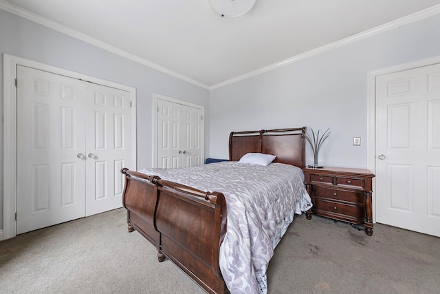 carpeted bedroom with crown molding and two closets