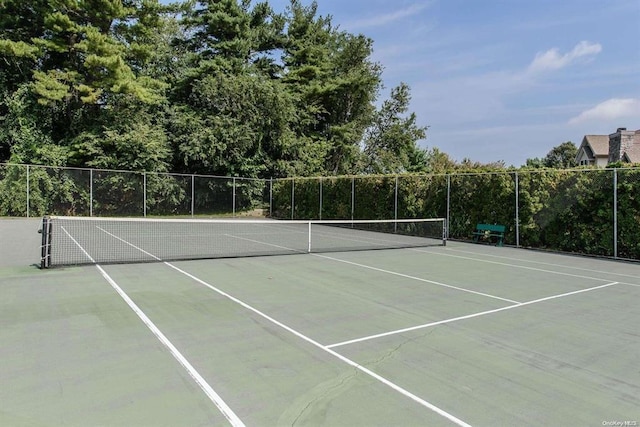 view of tennis court featuring fence and community basketball court