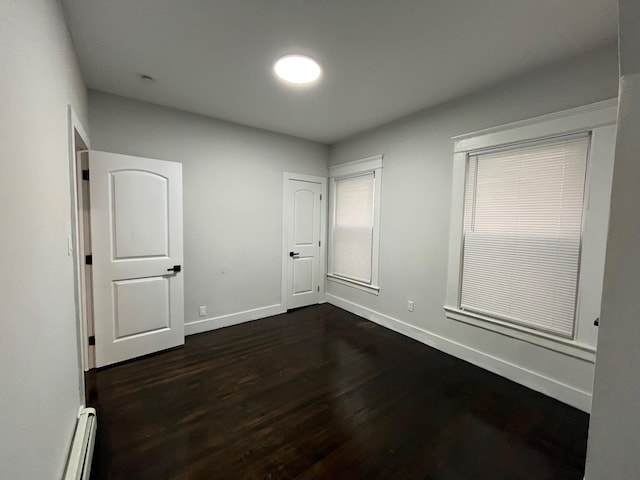 563 E 3rd St, Mount Vernon, NY 10553 - empty room featuring a baseboard radiator, baseboards, and dark wood-style flooring