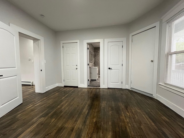 563 E 3rd St, Mount Vernon, NY 10553 - unfurnished bedroom with baseboard heating, dark wood finished floors, and baseboards