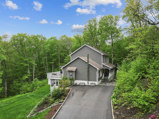 25 Crest Rd, Cold Spring, NY 10516 - view of front of house featuring asphalt driveway, a wooded view, and a front lawn