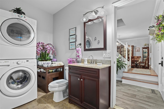 25 Crest Rd, Cold Spring, NY 10516 - bathroom with estacked washer and dryer, vanity, toilet, and ornamental molding