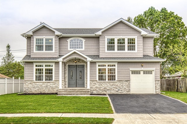 view of front of home with stone siding, asphalt driveway, and a garage
